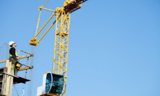 Crane hit scissor lift, injured operator