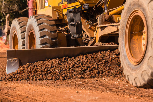 Construction worker run over by grader