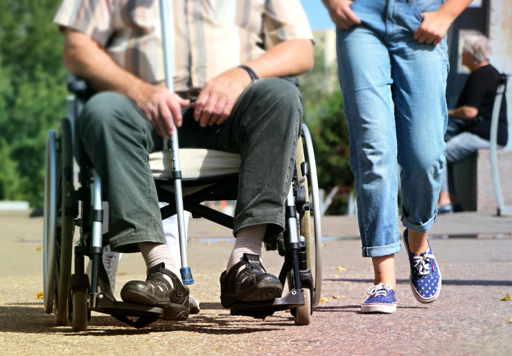 man in a wheelchair with an attendant whose training was an eligible medical expense