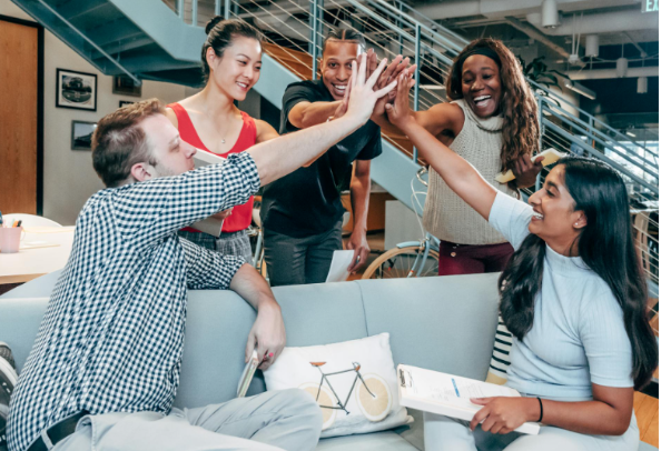 a team high fiving each other after meeting their goals under the incentive compensation management plan