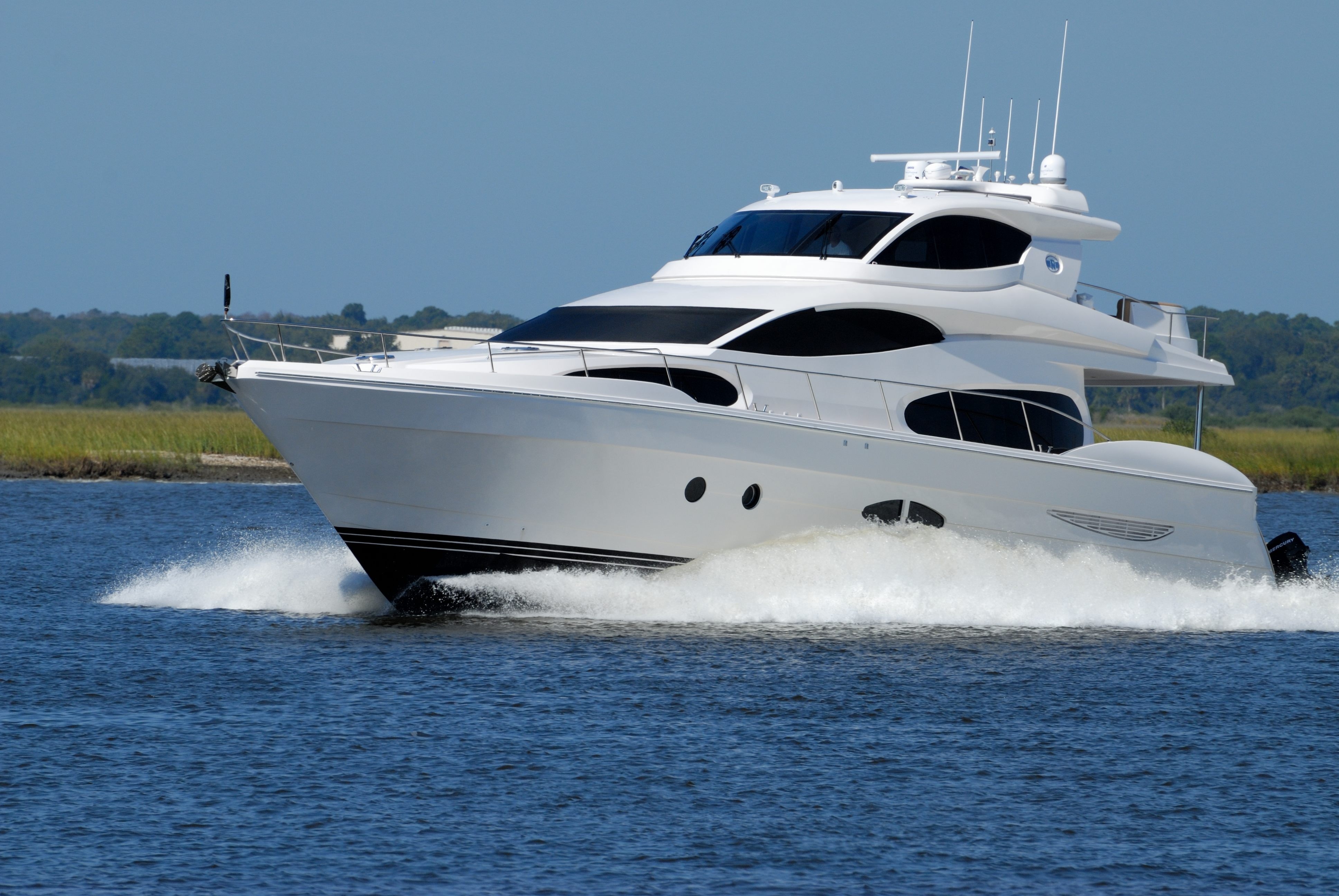 white luxury yacht speeding on blue waters
