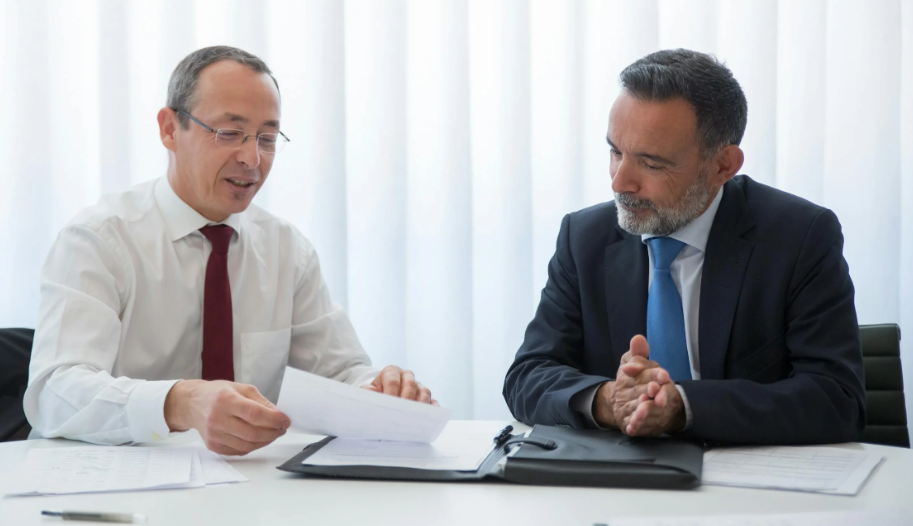lawyer holding a sheet of paper while discussing details of Canadian spousal sponsorship with his client