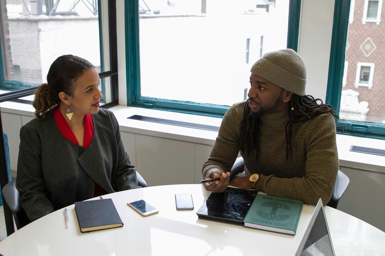 A senior HR officer and a young male employee at a table during an exit interview 
