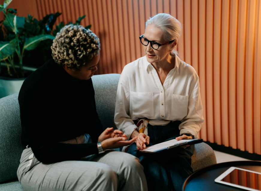 two ladies next to each other on a couch during an exit interview, which is part of employee turnover 