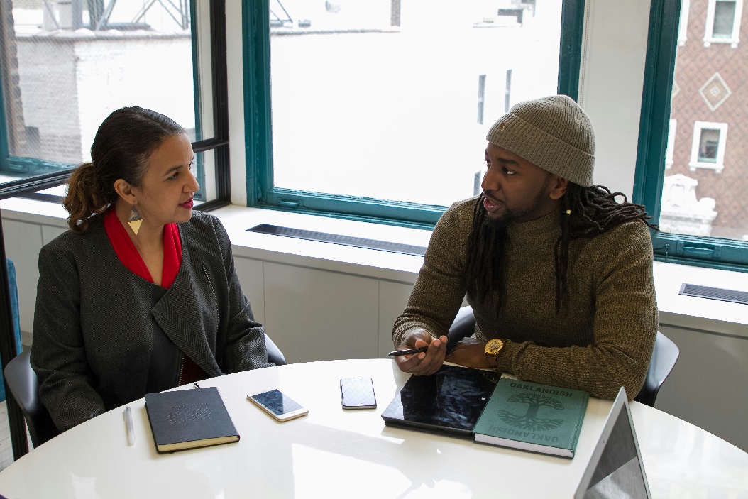  A senior HR officer and a young male employee at a table during an exit interview