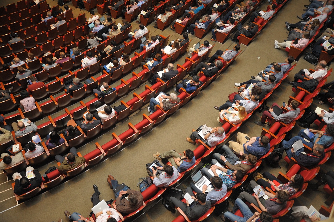  top view of company all-staff meeting discussing policies on sick leave and requesting doctor’s notes from employees