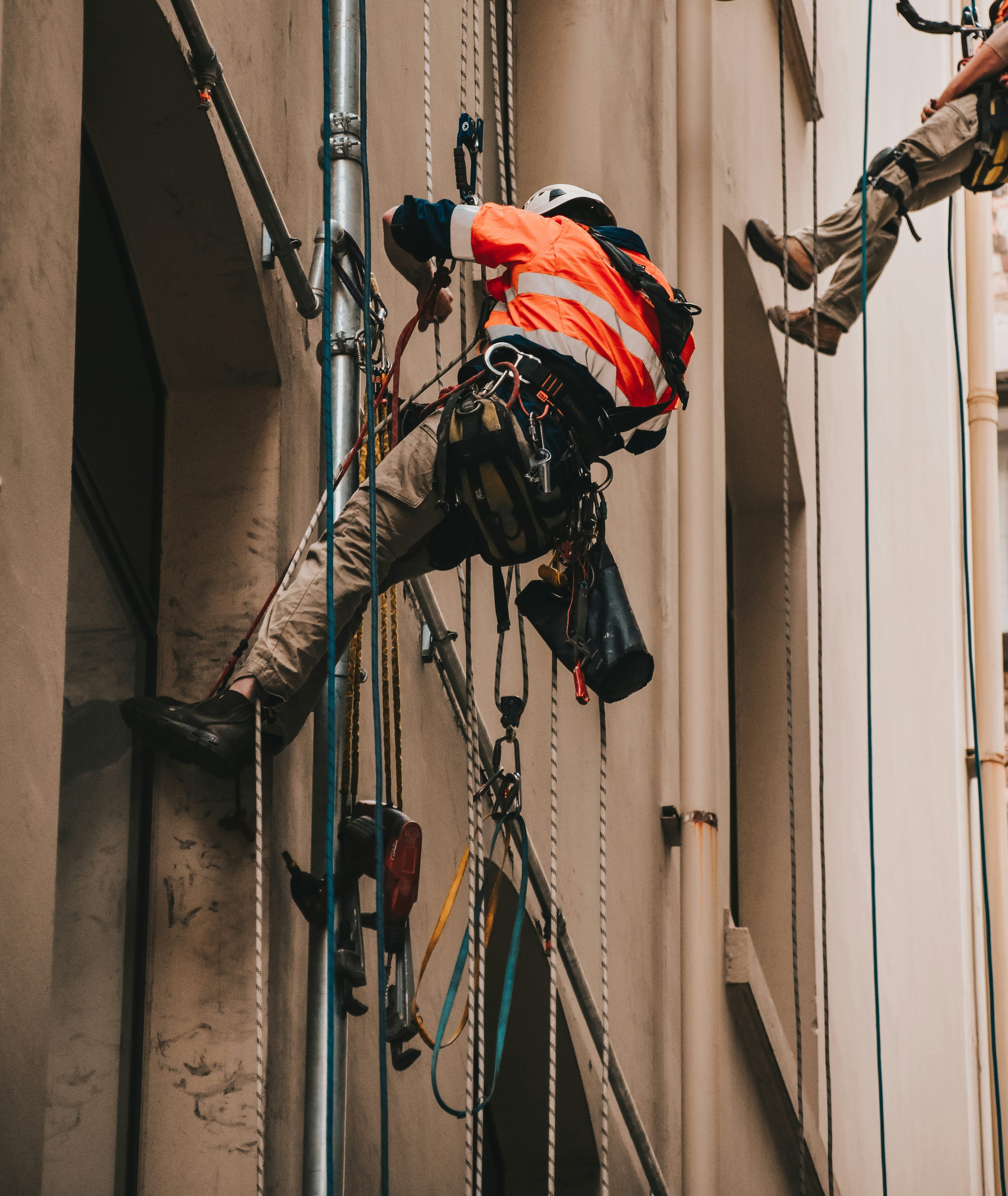  worker wearing safety harness while on side of building