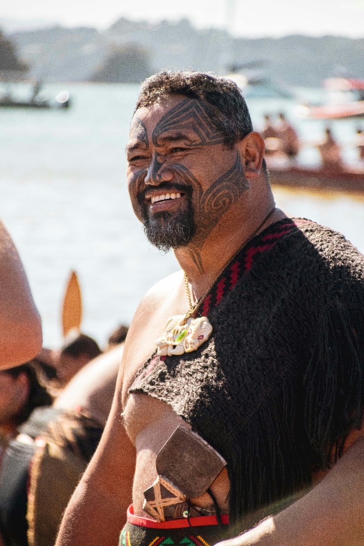 smiling Maori man with the New Zealand seascape as background