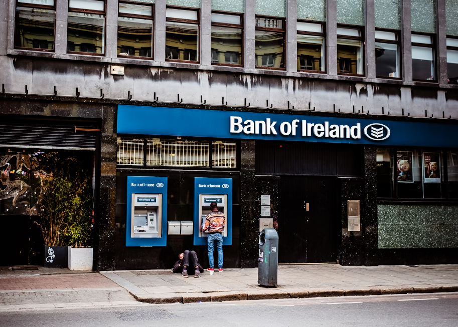 a consumer uses the ATM machine in front of a branch of Bank of Ireland for intermediaries in Dublin, Ireland