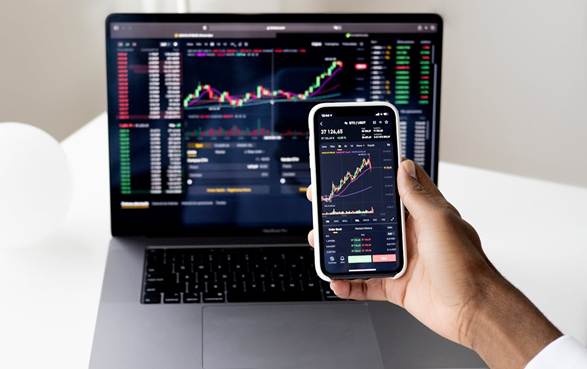 Laptop and smartphone displaying stock market metrics of dividend stocks, a smart passive income strategy