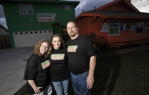 Sarah Hostetler (C) and her parents Beth and Scott pose in front of their home in Buena Park, California